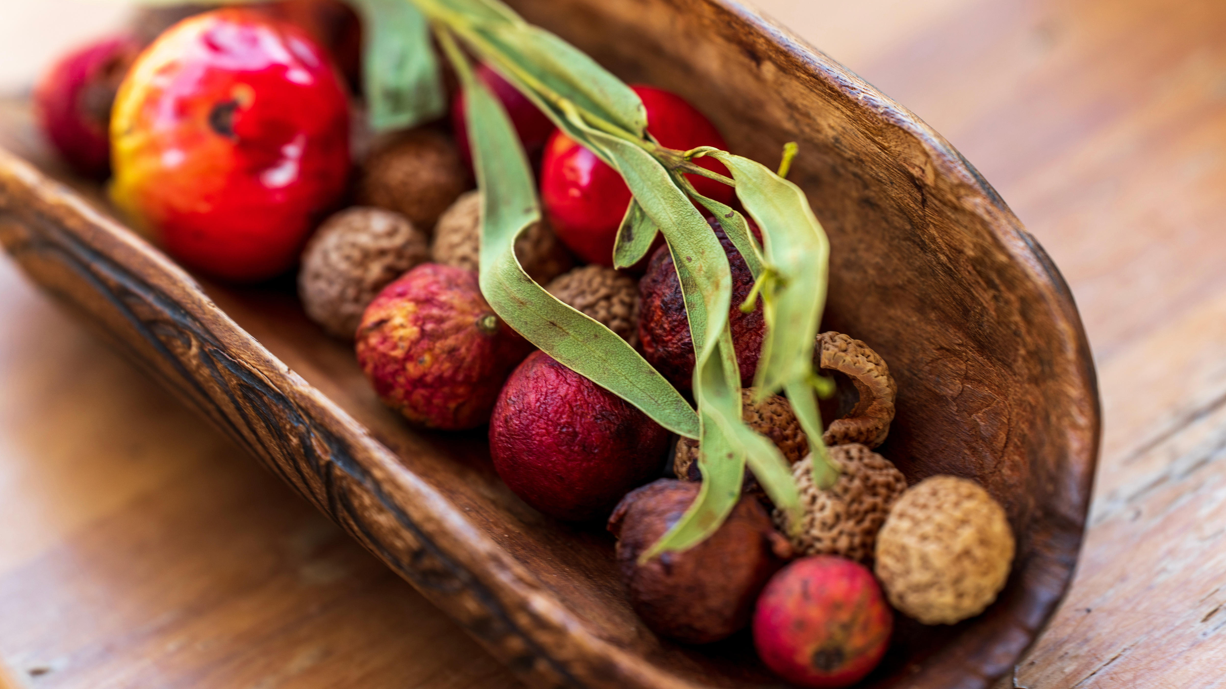 Some native fruits sitting in a wooden bowl