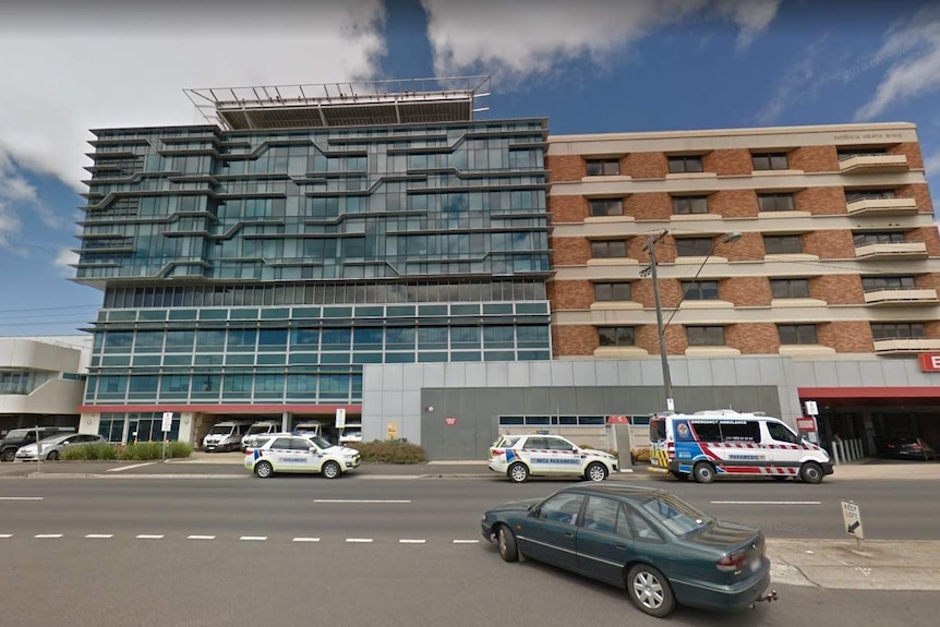 A street view of the University Hospital Geelong, which is a combination of glass and brick building.