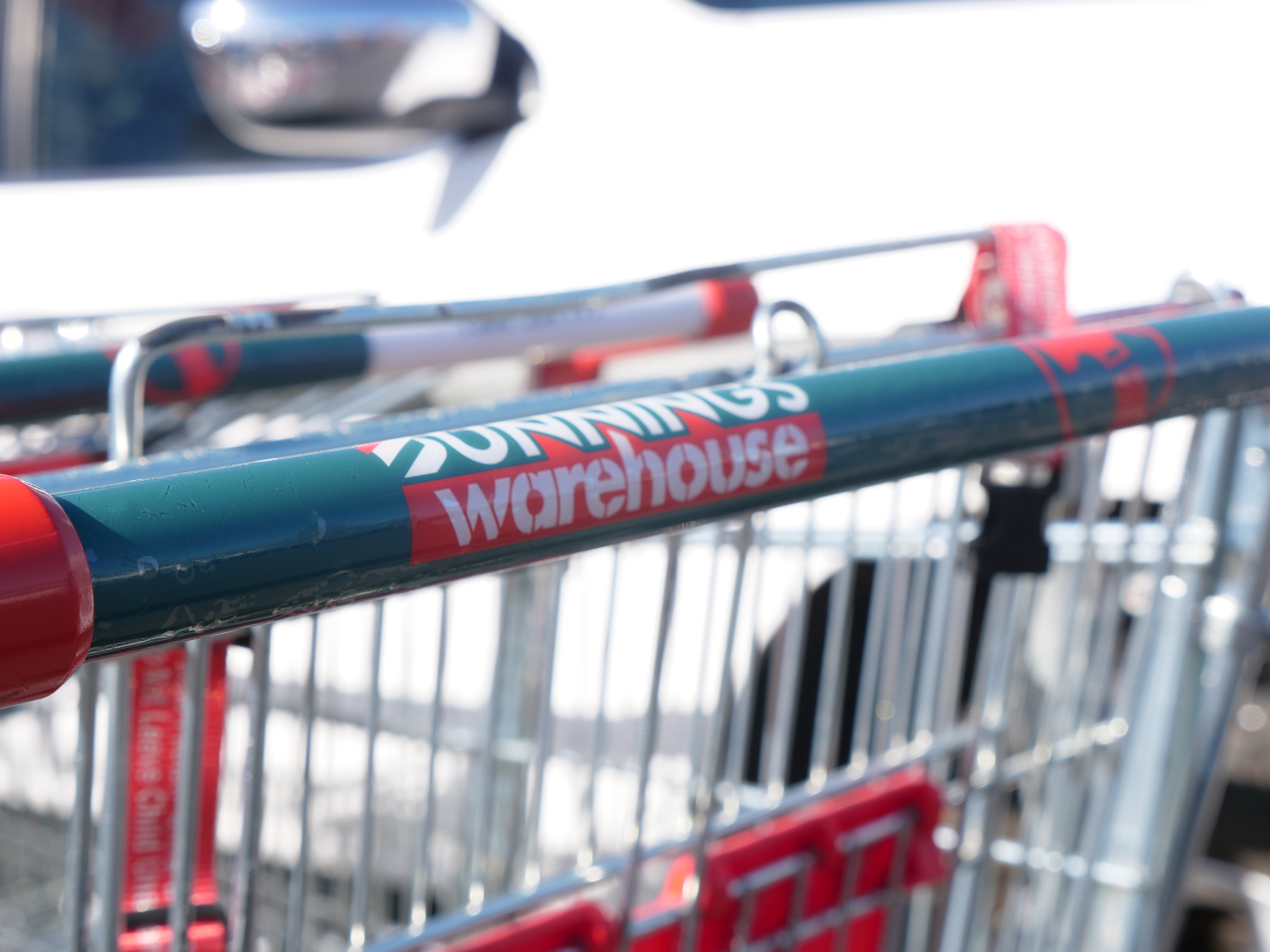 A close up of the handle of a Bunnings shopping trolley.