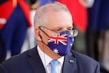 Morrison wearing an Australian flag print face mask with a headphone in his ear