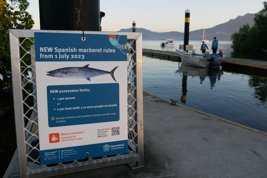 Sign informing of new Spanish mackerel changes is attached to a sign at a jetty. 