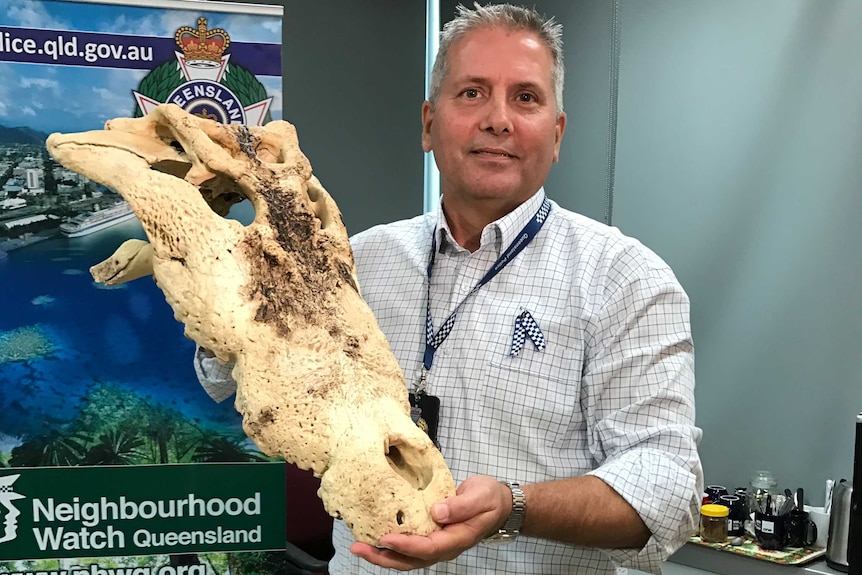 Geoffrey Marsh holds the skeleton head of a crocodile