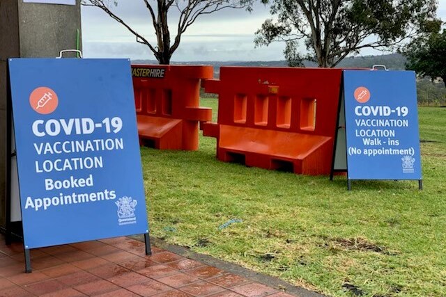 Two blue signs advertising the COVID-19 vaccination clinic in Toowoomba