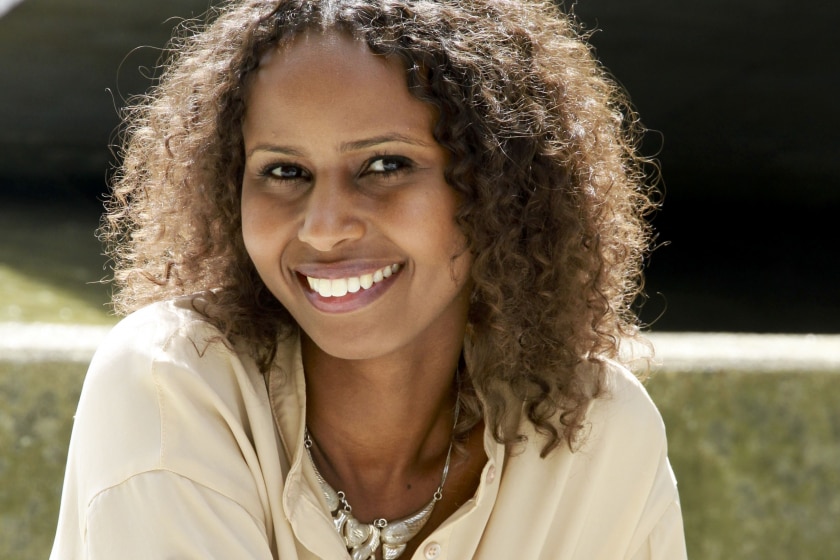 A woman wearing a cream shirt smiling.