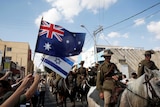 People wave Australian and Israelis flags.