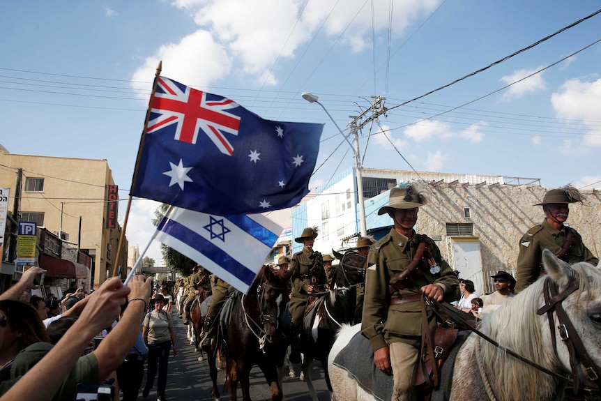 People wave Australian and Israelis flags.
