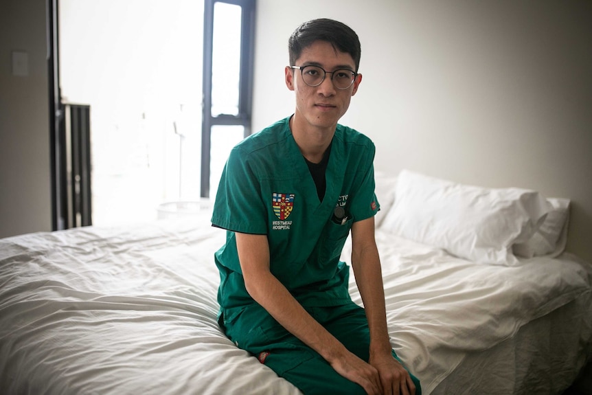 a doctor in scrubs sitting on a bed