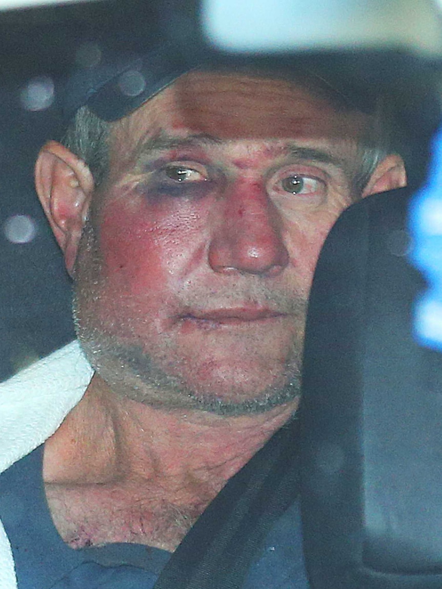 Gino Stocco sits in the back of a police vehicle as he is taken into Dubbo police station