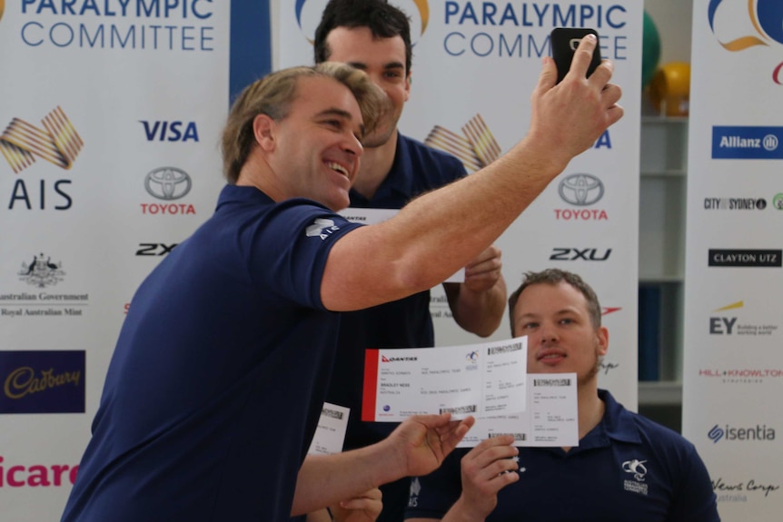 Brad Ness takes a selfie with fellow teammates and their plane tickets to Rio.