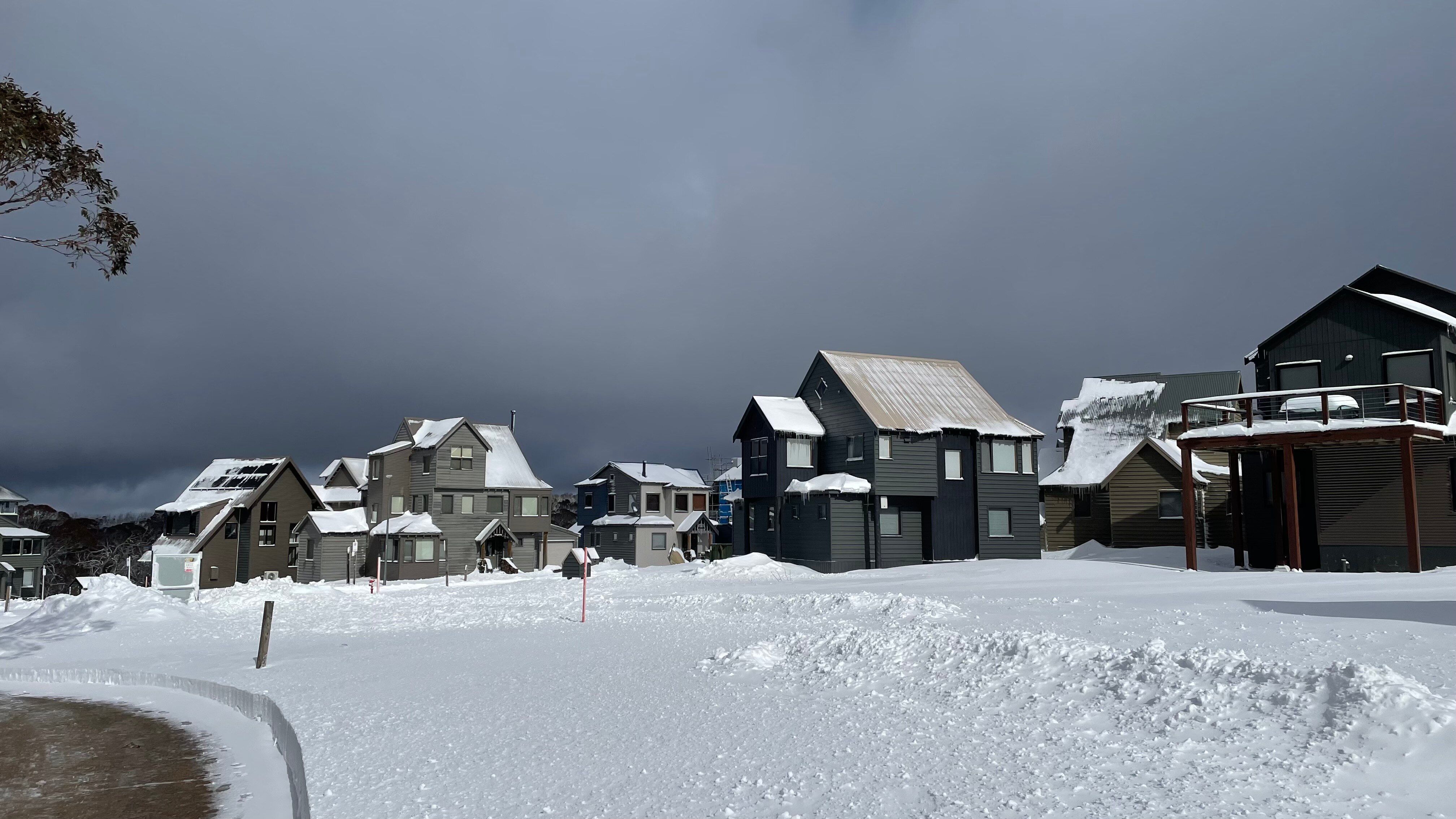 Snow-covered houses and snow on the ground in Dinner Plain, Victoria