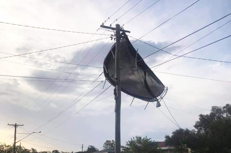 Remains of a trampoline hangs on powerlines after a storm at Raceview, west of Brisbane.