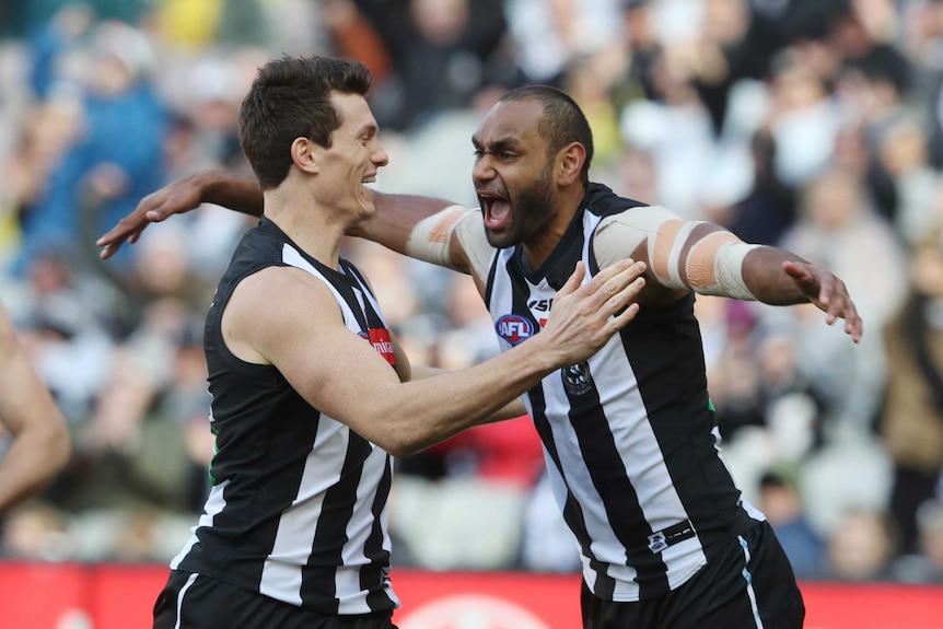 Travis Varcoe and Brody Mihocek celebrate a Collingwood goal.