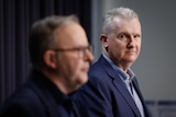 Tony Burke in focus standing next to Anthony Albanese out of focus