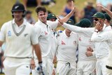 Australian team members congratulate Mitchell Marsh after taking the wicket of Corey Anderson