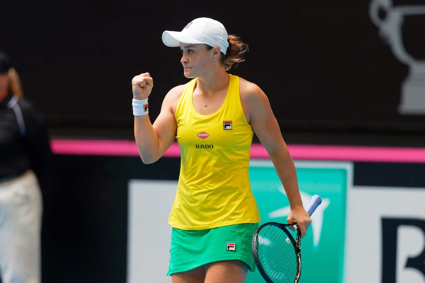 A female tennis player pumps her fist in satisfaction after winning her match in the Fed Cup final.