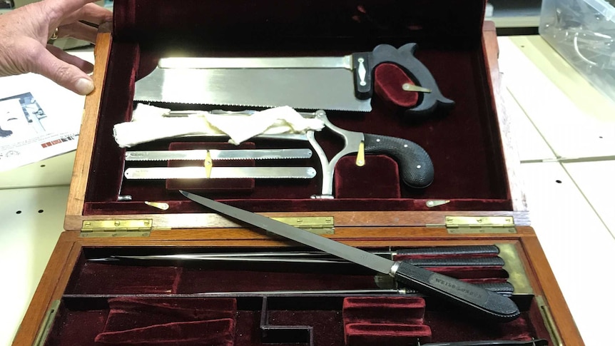 Antique surgery kit in a velvet-lined case, complete with filleting knives and bone saws.