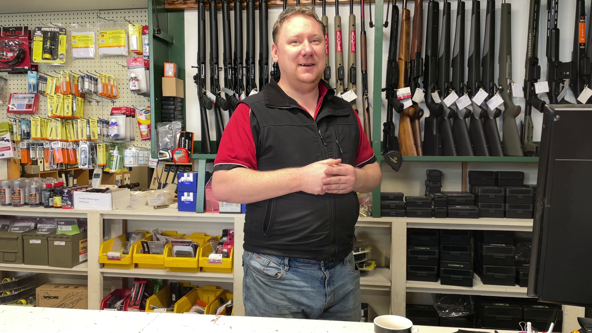 Zaine Beaton owner of Beaton firearms stands happily in his store as he talks with reporter. 