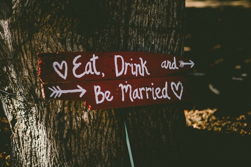 A sign at a wedding says "Eat, Drink and Be Married".