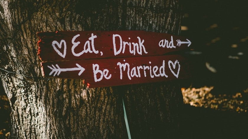 A sign at a wedding says "Eat, Drink and Be Married".