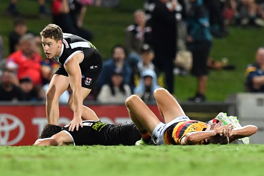 Two players laying on the ground after they collided during an afl match
