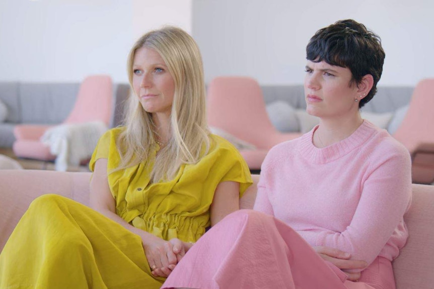 Gwyneth Paltrow and Elise Loehnen sit on couch during interview on The Goop Lab.