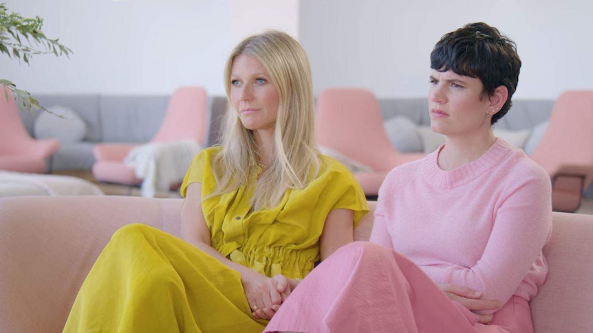 Gwyneth Paltrow and Elise Loehnen sit on couch during interview on The Goop Lab.