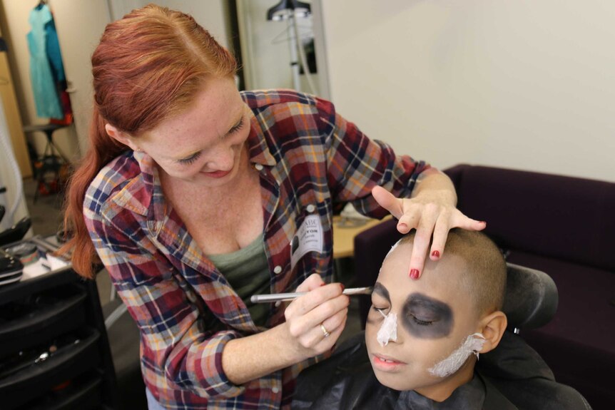 J'Won Cameron gets eyeshadow added to his face as part of a 'zombie makeover'