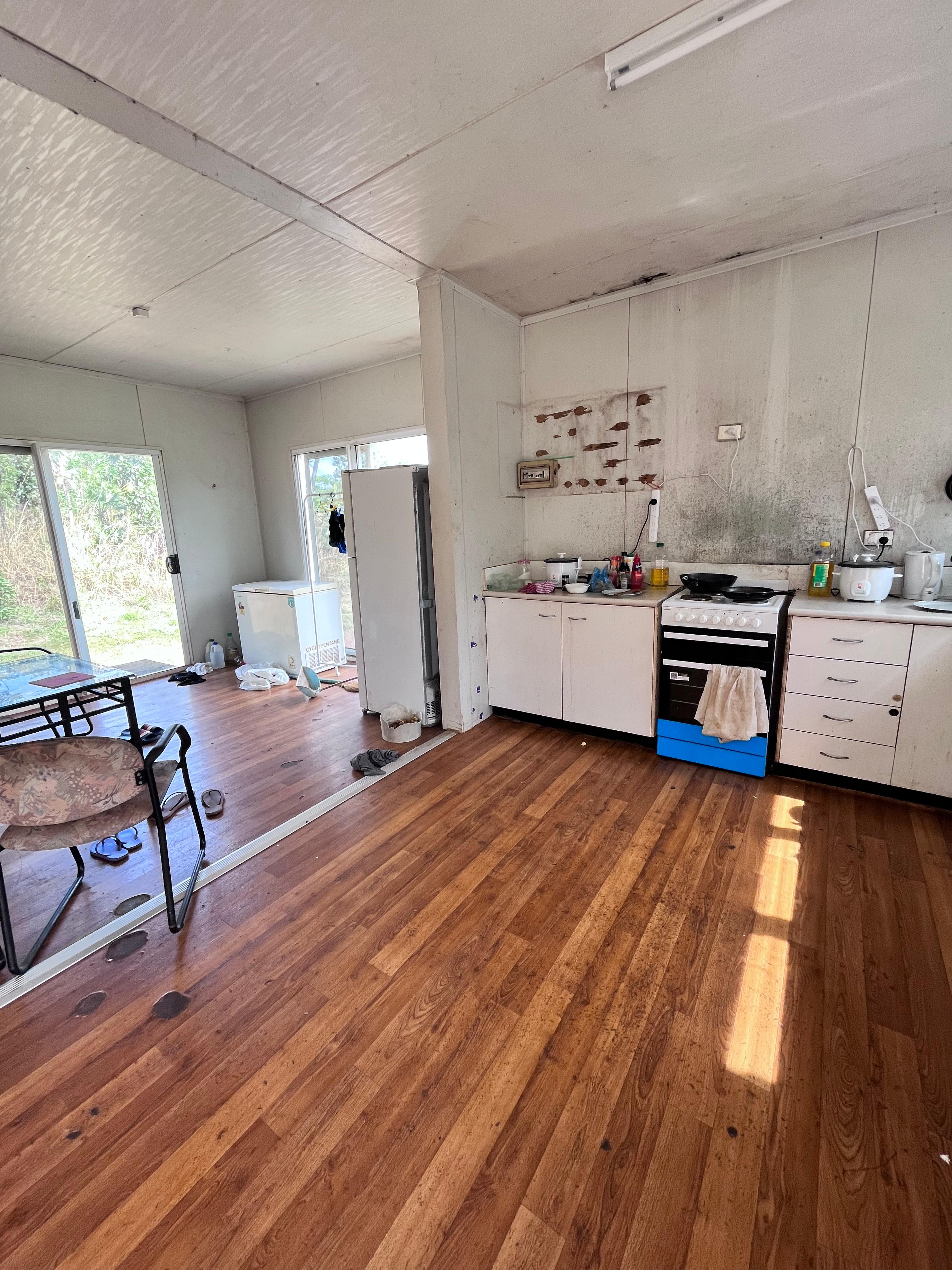 A kitchen in poor condition with mould on the walls.