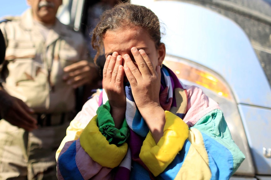 A girl from eastern Mosul cries after fleeing her home and father