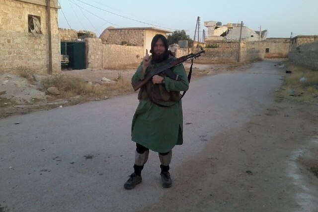 Mark Taylor holding a gun in Syria.