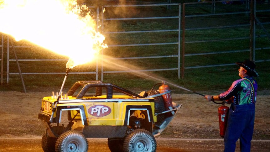 A rodeo clown extinguishes a fire on a mini truck at Royal Bathurst Show.