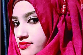 A woman with red lipstick wears a red headscarf.