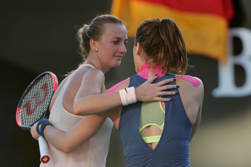 Andrea Petkovic (R) and Petra Kvitova hug at the net after their first-round match at the Australian Open.