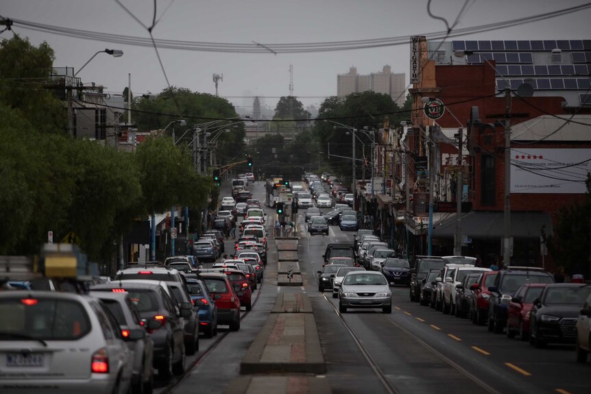 Gloomy street with lots of traffic in Northcote in the rain.