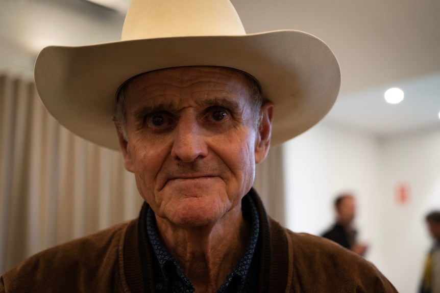 Portrait shot of an older man wearing a wide-brimmed hat.