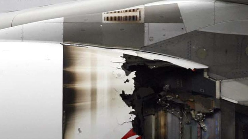 Technicians look at the damaged engine of the Qantas A380.
