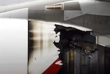 Technicians look at the damaged engine of the Qantas A380.