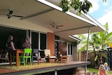 Two people stand on deck of completed renovation of house of Edge Hill in Cairns.