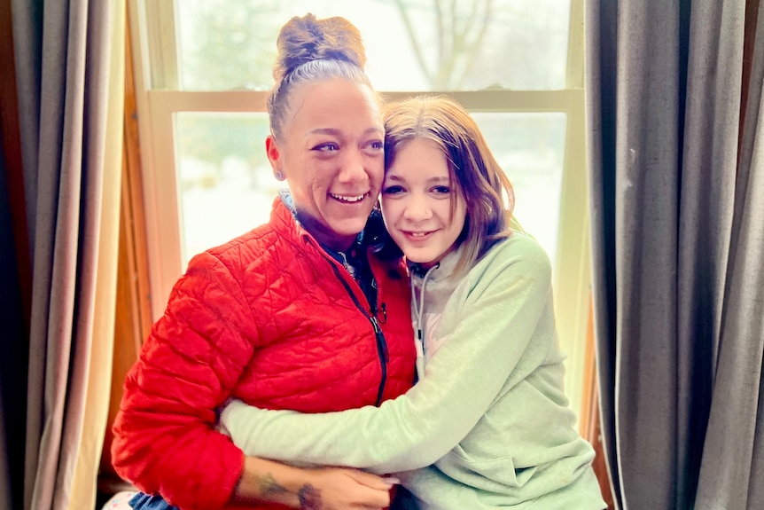 Mother and daughter hugging each other.