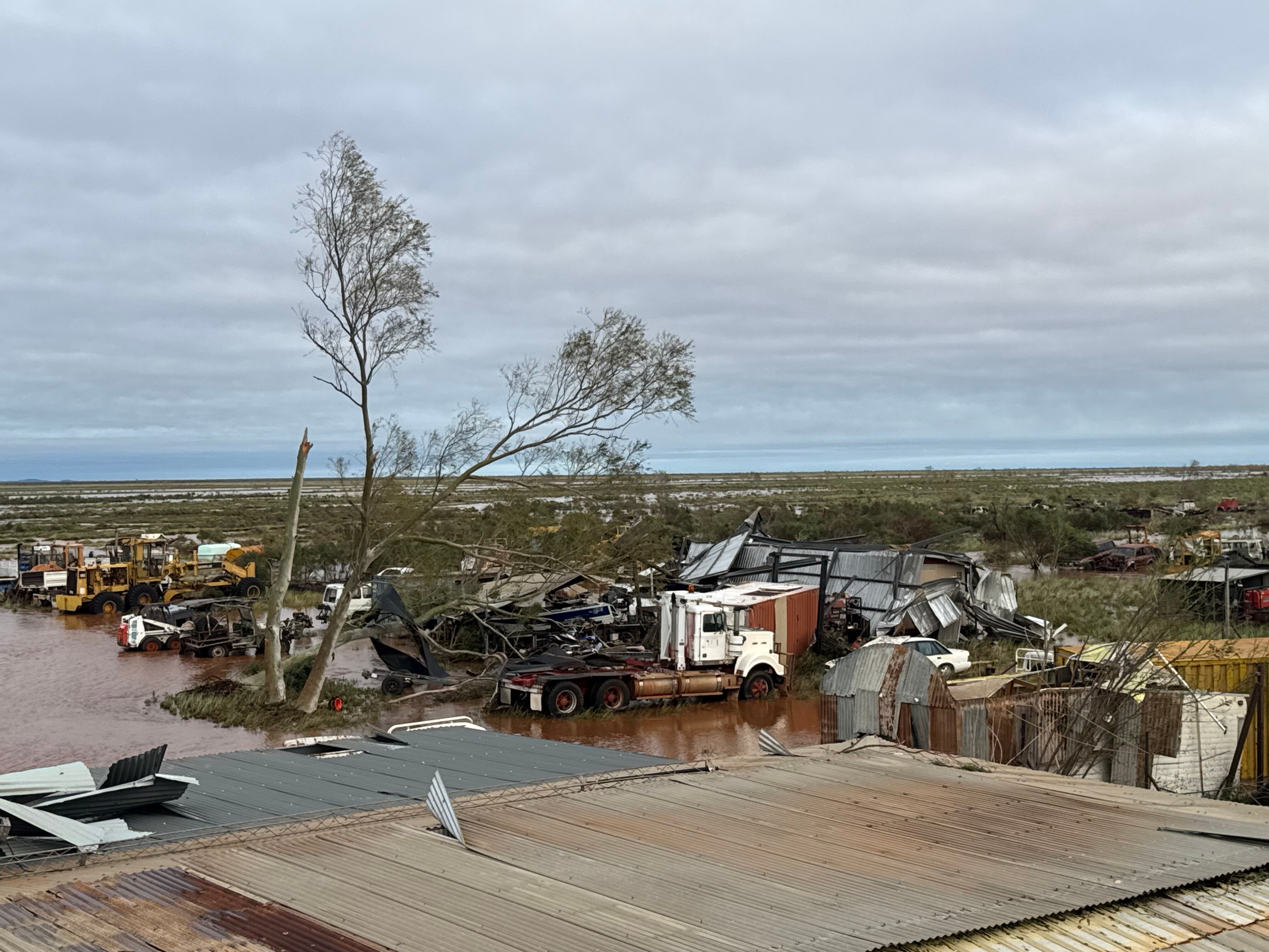 Scattered tin sheets and building degree with flooded road