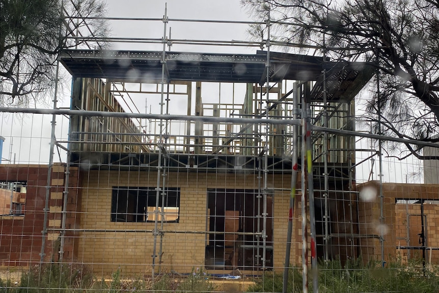 Cindy Richardson's incomplete house in Tapping, with scaffolding, no walls on upper storey