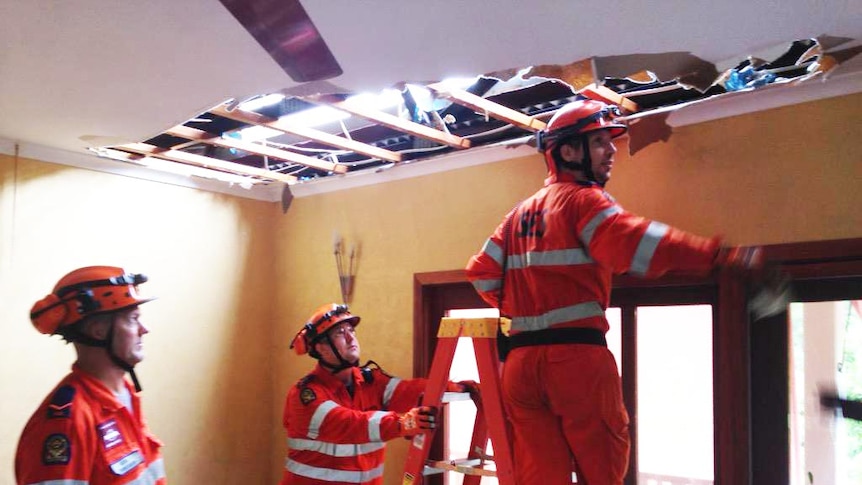 SES volunteers fix a hole in a roof