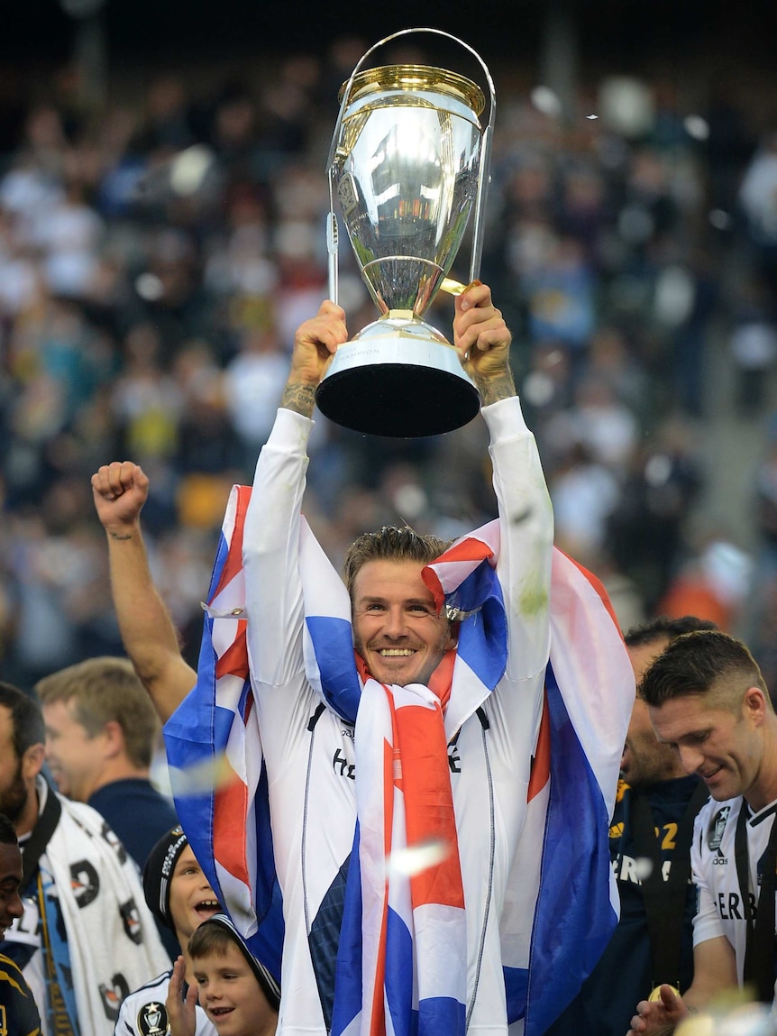 Out with a bang ... David Beckham lifts the MLS Cup for the second time in his career.