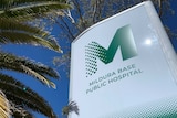 a Mildura Base Hospital sign with a blue sky and a palm tree in the background