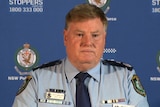 police officer looking stern at a press conference