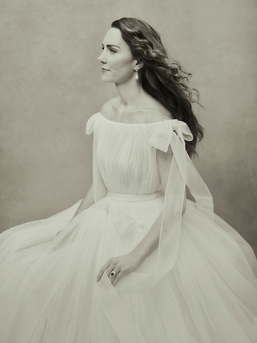 凯特·米德尔顿 (Kate Middleton) 身着飘逸的白色连衣裙，坐在三幅新的皇室肖像中的一幅中，望向远方。
