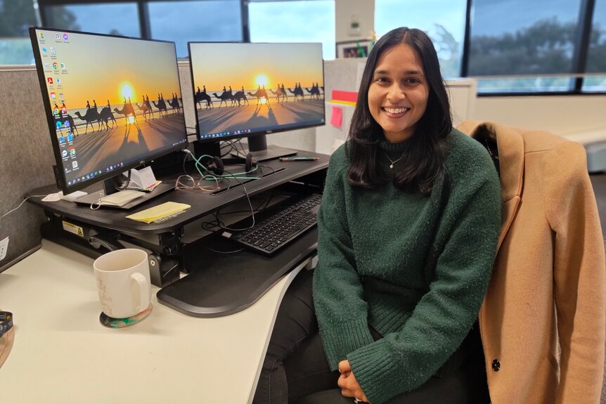 Anupriya Sharma sits at her desk at work. 
