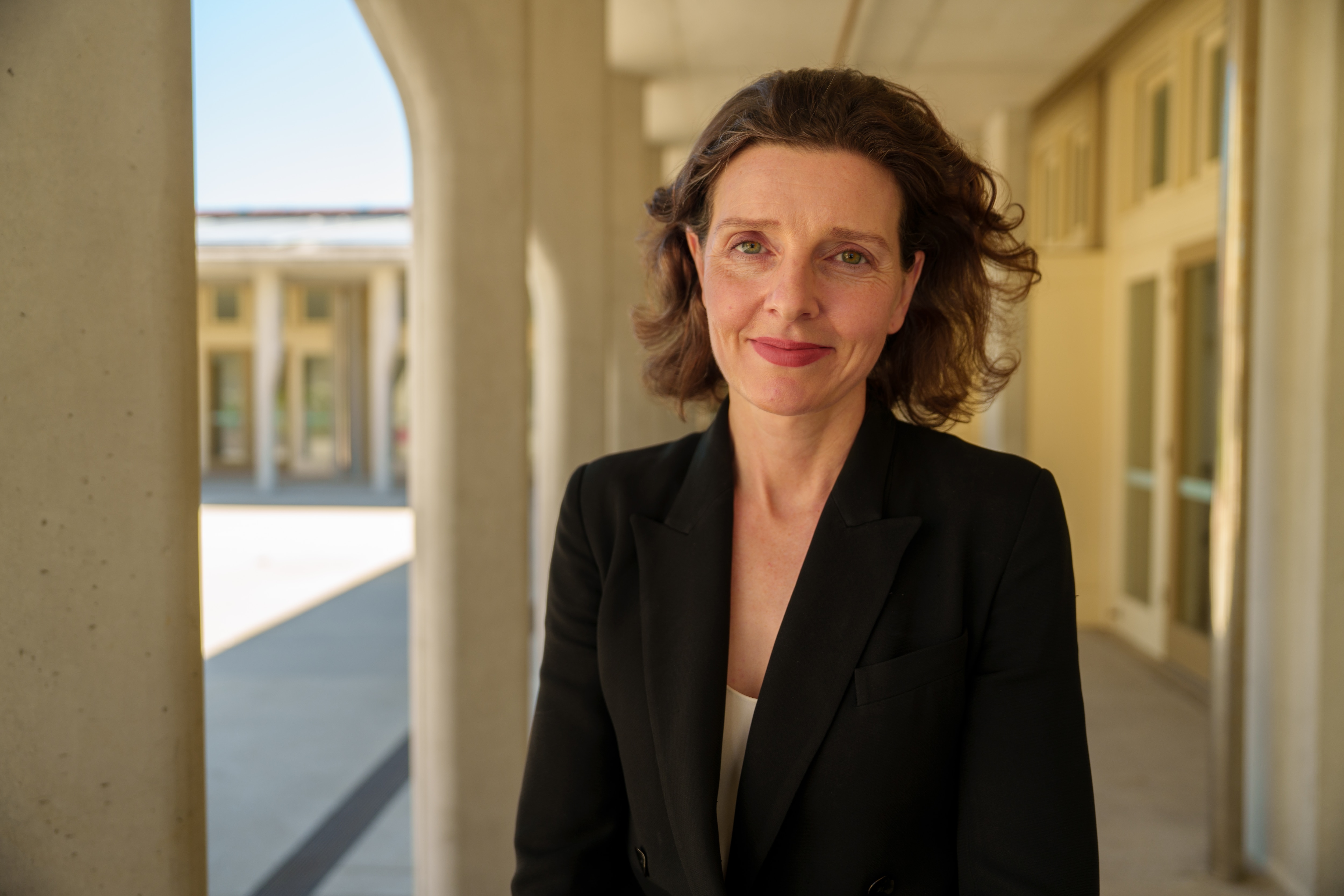 Donación de Allegra con una chaqueta formal y oscura