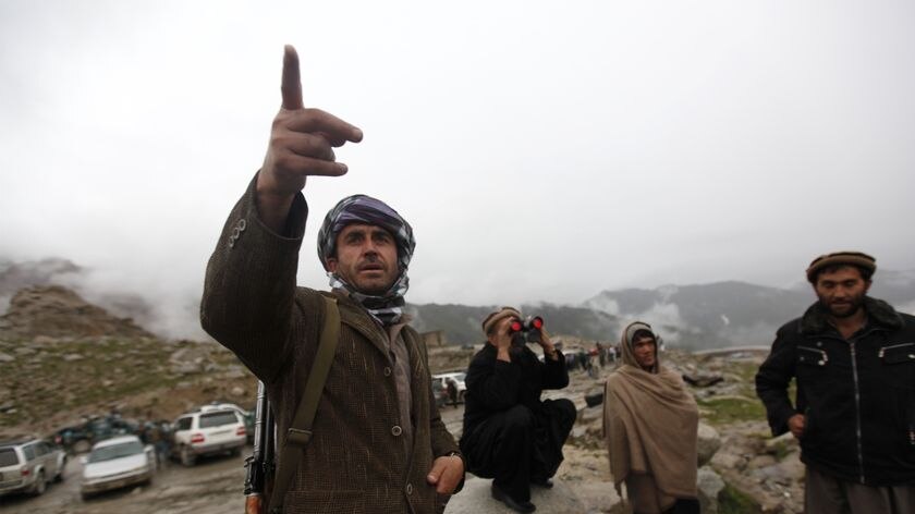 An Afghan man points to where an Afghan airliner Pamir plane is believed to have crashed
