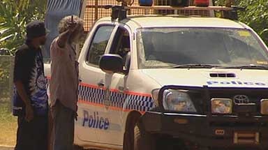 Two Indigenous men talking to police in car in the NT community of Wadeye